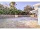 Spacious backyard with a wooden fence line and mature trees providing shade at 1131 Dartmouth Dr, Holiday, FL 34691