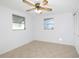 Bright bedroom featuring tiled floors, a ceiling fan, two windows, and a closet at 1131 Dartmouth Dr, Holiday, FL 34691