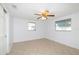 Light and airy bedroom with tiled floors, ceiling fan, and natural light from the windows at 1131 Dartmouth Dr, Holiday, FL 34691