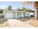 Charming single-story home with a light blue exterior, an attached garage, and a well-manicured front yard at 1131 Dartmouth Dr, Holiday, FL 34691