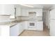 Updated kitchen features white cabinets, granite counters, tile backsplash and stainless-steel appliances at 1131 Dartmouth Dr, Holiday, FL 34691