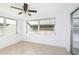 Bright sunroom featuring tile flooring, multiple windows, a ceiling fan, and direct access to the outdoors at 1131 Dartmouth Dr, Holiday, FL 34691
