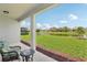 Covered back porch featuring comfortable seating and a serene pond view at 12004 Cinnamon Fern Dr, Riverview, FL 33579