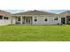 Well-maintained backyard with a lush lawn, a covered porch, and an AC unit at 12004 Cinnamon Fern Dr, Riverview, FL 33579