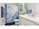 Well-lit bathroom with a white marble vanity, blue accent decor, and shower-tub combo at 12004 Cinnamon Fern Dr, Riverview, FL 33579