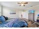 Bedroom with wood-look flooring, stylish bedding, chest of drawers, and a TV at 12004 Cinnamon Fern Dr, Riverview, FL 33579