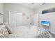 Bedroom with patterned bedding, carpeted floor, closet doors, and a TV on a stand at 12004 Cinnamon Fern Dr, Riverview, FL 33579