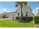 A home with a three-car garage, arched windows, dark roof and attractive landscaping at 12004 Cinnamon Fern Dr, Riverview, FL 33579