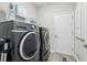 Laundry room featuring gray washer and dryer units, shelving, and wood-look flooring at 12004 Cinnamon Fern Dr, Riverview, FL 33579