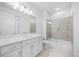 Bright bathroom featuring a tub/shower combo with glass doors, vanity with modern fixtures and a toilet at 12739 Rainwashed Loop, Parrish, FL 34219