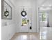 Bright foyer with white walls, tile floors, decorative wreath on front door, and a view into the living area at 12739 Rainwashed Loop, Parrish, FL 34219