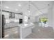Open-concept kitchen boasts white cabinetry, stainless steel appliances, large island, and a dining area at 12739 Rainwashed Loop, Parrish, FL 34219
