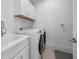 Practical laundry room featuring a utility sink, washer and dryer, and storage cabinets at 12739 Rainwashed Loop, Parrish, FL 34219