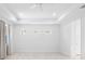 Bright main bedroom with tray ceilings, recessed lighting, and three windows at 12739 Rainwashed Loop, Parrish, FL 34219