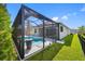 View of the backyard pool featuring a large screened in enclosure and lush landscaping at 12739 Rainwashed Loop, Parrish, FL 34219