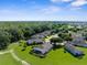 An aerial view of the community shows lush landscaping and well-maintained homes, including a screened-in pool at 1280 Hill Flower Dr, Brooksville, FL 34604