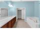 Bathroom featuring a double sink vanity, soaking tub, and blue walls at 1280 Hill Flower Dr, Brooksville, FL 34604
