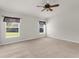 Spacious carpeted bedroom with ceiling fan and bright windows at 1280 Hill Flower Dr, Brooksville, FL 34604