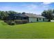 Exterior view of the home, showcasing the lush green lawn and screened patio at 1280 Hill Flower Dr, Brooksville, FL 34604