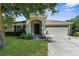 Charming single-story home featuring a manicured lawn, arched entryway and a two car garage at 1280 Hill Flower Dr, Brooksville, FL 34604