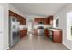 Kitchen with stainless steel appliances, dark wood cabinets, tile floors, and ample counter space at 1280 Hill Flower Dr, Brooksville, FL 34604