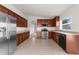 Open kitchen with stainless steel appliances, wood cabinets, tile floors, and abundant counter space at 1280 Hill Flower Dr, Brooksville, FL 34604