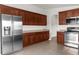 Modern kitchen with stainless steel appliances, dark wood cabinets, and tile floors at 1280 Hill Flower Dr, Brooksville, FL 34604