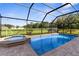 Sparkling pool and spa in screened enclosure with brick paver patio and lush green backyard at 1280 Hill Flower Dr, Brooksville, FL 34604