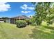 Backyard with a screened in patio, lush landscaping, and mature trees providing shade at 12904 Prestwick Dr, Riverview, FL 33579