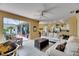 Bright living room with neutral tones, ceiling fan, and sliding door to screened patio at 12904 Prestwick Dr, Riverview, FL 33579