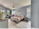 Serene main bedroom with large windows, ceiling fan, and wood-look flooring at 12904 Prestwick Dr, Riverview, FL 33579