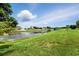 A picturesque water view showcases waterfront homes with screened lanais and beautifully landscaped lawns under a partly cloudy sky at 12904 Prestwick Dr, Riverview, FL 33579