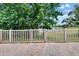 A brick patio with a white fence, offering scenic views of the lake and lush greenery at 14047 Weddington Ter, Hudson, FL 34669