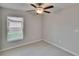 Bedroom is well-lit by a window and has a ceiling fan with carpet at 14047 Weddington Ter, Hudson, FL 34669
