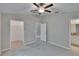 Bedroom features a ceiling fan, neutral carpet, and multiple doorways leading to other rooms at 14047 Weddington Ter, Hudson, FL 34669