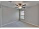 Bedroom features neutral carpet, ceiling fan, and natural light through a window at 14047 Weddington Ter, Hudson, FL 34669