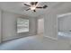 Bright carpeted bedroom with ceiling fan, closet, and neutral paint at 14047 Weddington Ter, Hudson, FL 34669