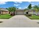 Charming single Gathering home showcasing a well-manicured lawn, palm trees, and a neutral-toned exterior at 14047 Weddington Ter, Hudson, FL 34669