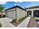 View of the home's side showing an attached two-car garage and arched entrance at 14047 Weddington Ter, Hudson, FL 34669