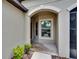 Arched front door entrance showcasing exterior landscaping at 14047 Weddington Ter, Hudson, FL 34669