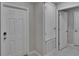 Hallway view of an interior entry door adjacent to a hallway with two additional doors and tile flooring at 14047 Weddington Ter, Hudson, FL 34669