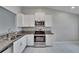Kitchen featuring stainless steel oven, granite countertops, and white cabinets at 14047 Weddington Ter, Hudson, FL 34669
