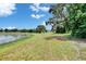 A sprawling backyard with a lush green lawn and a picturesque view of the tranquil lake at 14047 Weddington Ter, Hudson, FL 34669