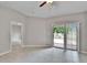 Living room with tile floors, ceiling fan, and access to outdoor patio and another room at 14047 Weddington Ter, Hudson, FL 34669