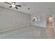 Bright living room with tile floor, a ceiling fan, and a pass-through to the modern kitchen at 14047 Weddington Ter, Hudson, FL 34669