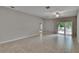 Spacious living room featuring tile flooring, neutral paint, a ceiling fan, and access to outdoor patio at 14047 Weddington Ter, Hudson, FL 34669