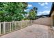 Paver patio with view of the lake, fenced and lush landscaping at 14047 Weddington Ter, Hudson, FL 34669