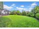 Expansive backyard with lush green lawn and a screened lanai, perfect for outdoor enjoyment at 15405 Woodstar Landing Ct, Lithia, FL 33547