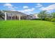 Beautiful backyard featuring a large lawn, a screened-in lanai, and sliding glass doors at 15405 Woodstar Landing Ct, Lithia, FL 33547