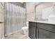 Well-lit bathroom featuring a vanity with a granite countertop and a tiled shower with a curtain at 15405 Woodstar Landing Ct, Lithia, FL 33547